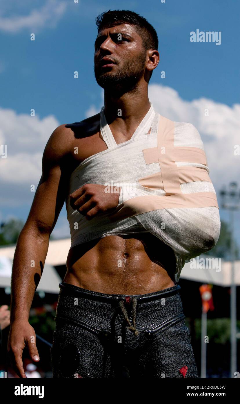 A bandaged wrestler watches competition after being treated for a shoulder injury at the Kirkpinar Turkish Oil Wrestling Festival at Edirne in Turkiye Stock Photo