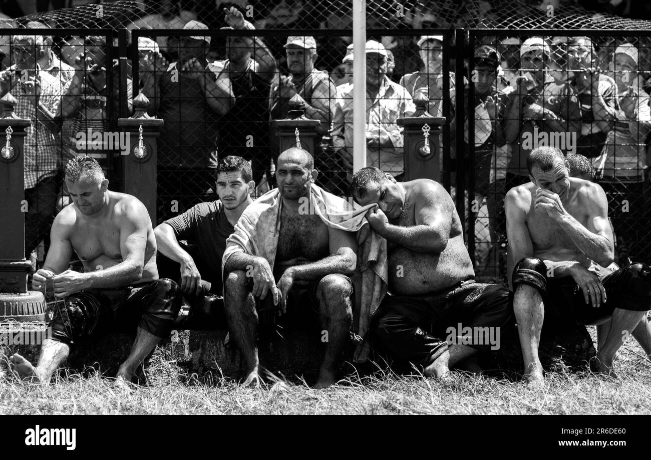 Exhausted wrestlers relax within the arena after competing at the Kirkpinar Turkish Oil Wrestling Festival at Edirne in Turkiye. Stock Photo