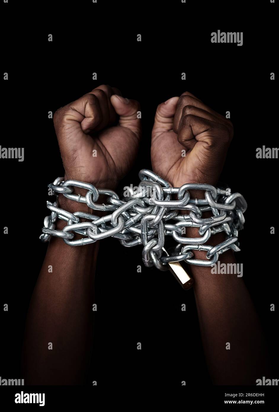 Chain, hands and prisoner of slavery isolated in studio on a black background. Chained, slave and hand of person in bondage, hostage or criminal in Stock Photo