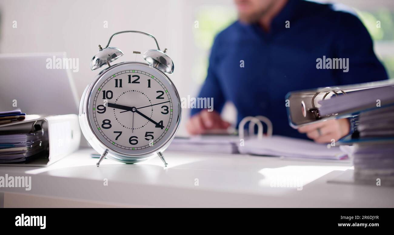 Accountant Calculating Bill With Time Clock. Money Alarm Stock Photo