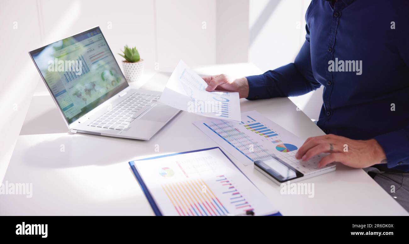 Business Accountant Using Finance Chart Document And Calculator Stock Photo
