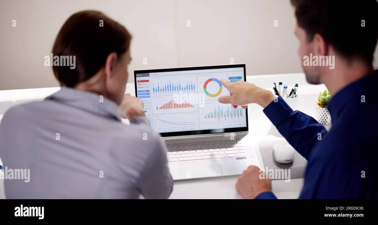 Two Analyst Using KPI Dashboard On Laptop Computer Stock Photo