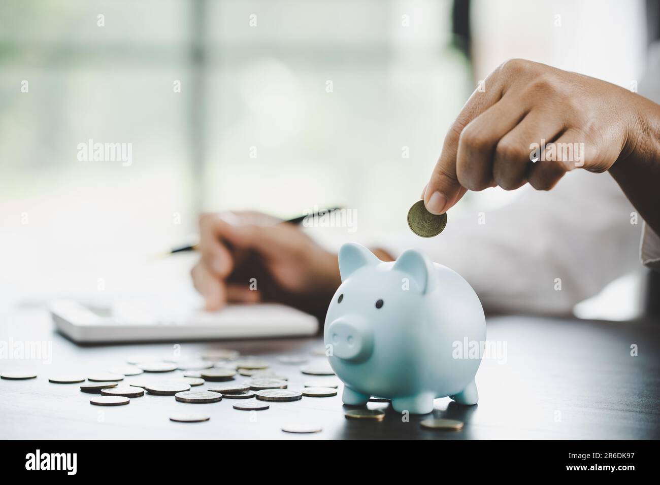 woman hand putting money into piggy for saving money wealth and ...