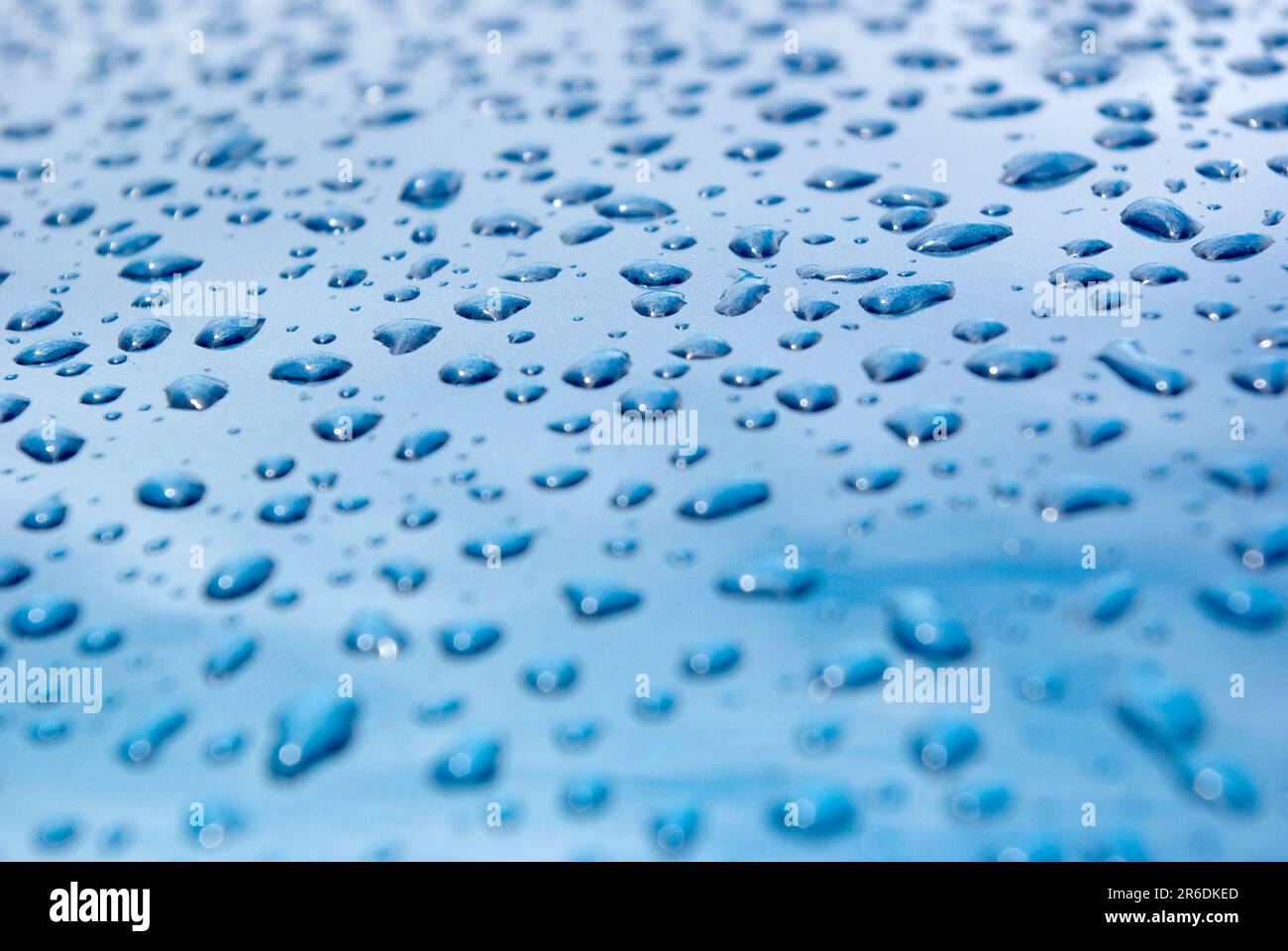 Raindrops on Bonnet of a Blue Car Stock Photo