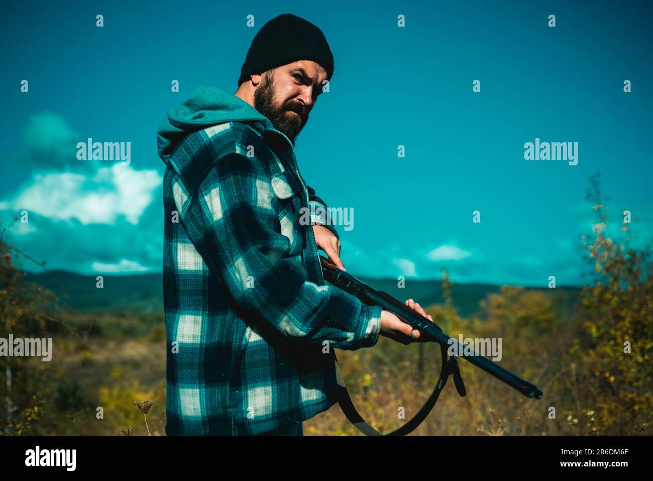Hunter with shotgun gun on hunt. Hunting without borders. Clothes for the hunter. Close up Portrait of hamdsome Hunter. Stock Photo