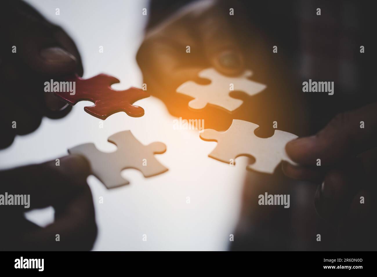 Hands holding piece of blank jigsaw puzzle for teamwork workplace