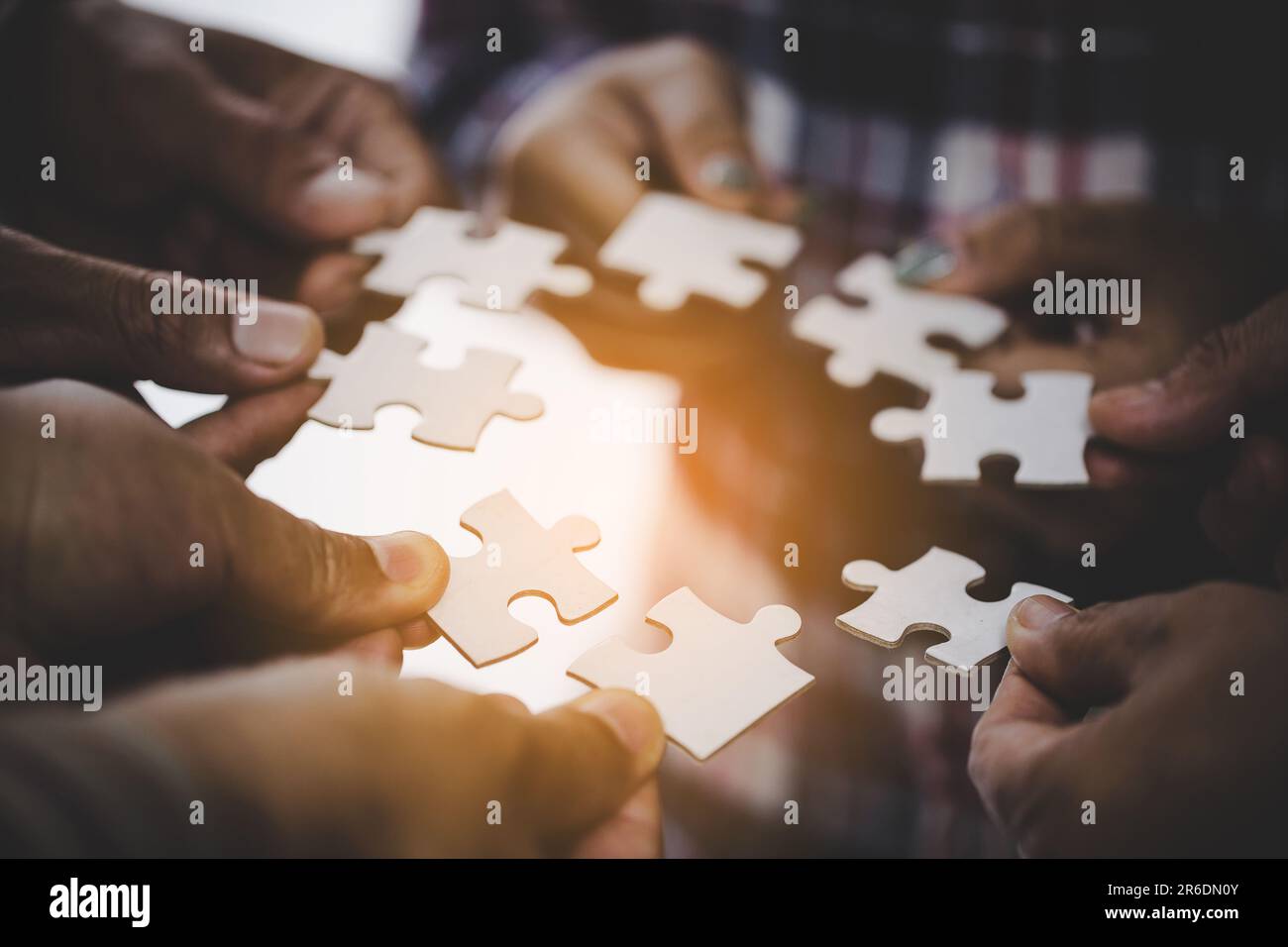 Hands holding piece of blank jigsaw puzzle for teamwork workplace