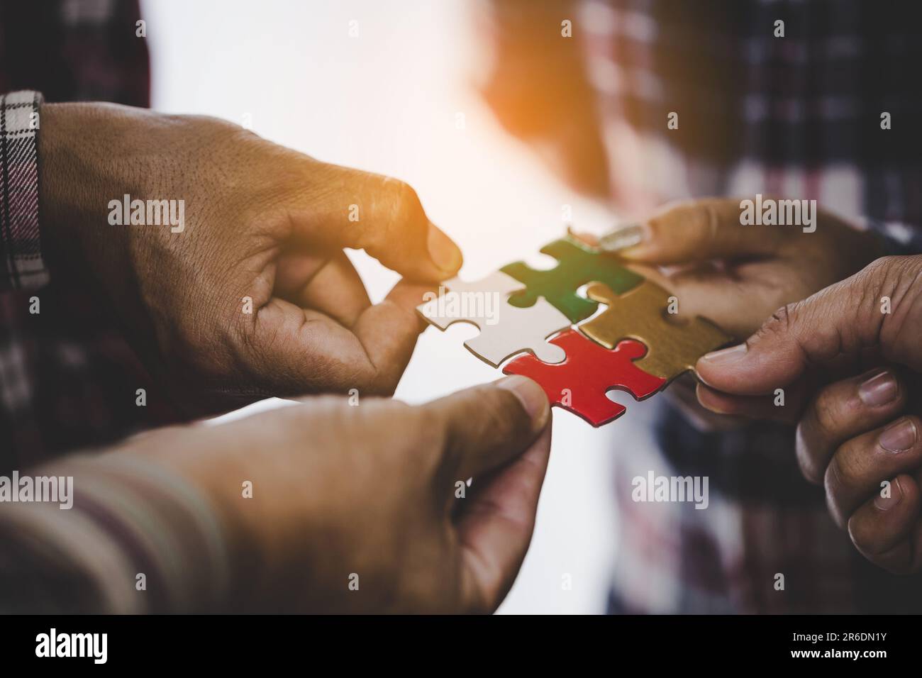 Hands holding piece of blank jigsaw puzzle for teamwork workplace