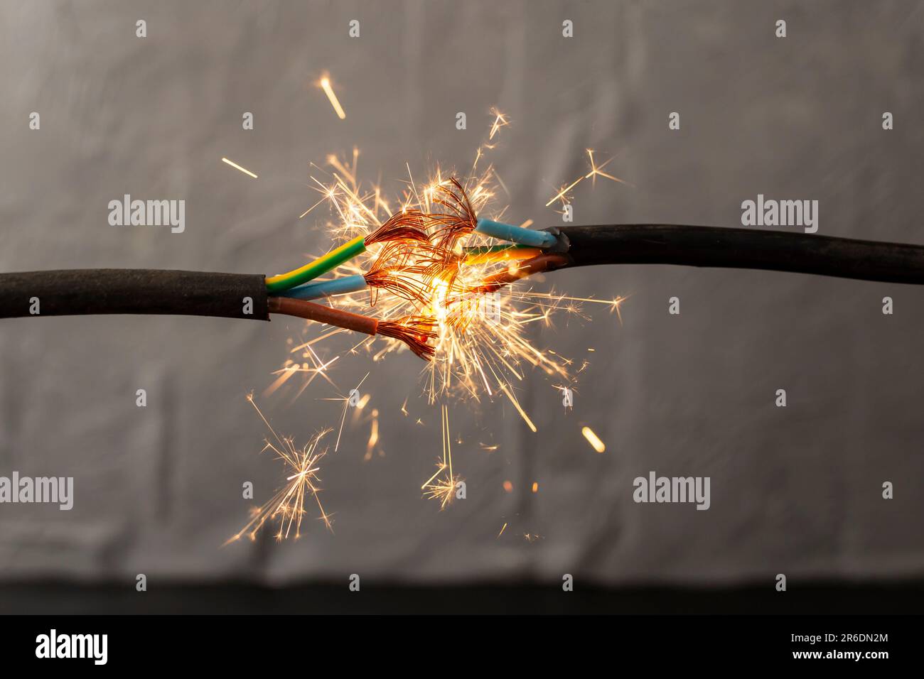 sparks explosion between electrical cables, fire hazard concept, soft focus close up Stock Photo