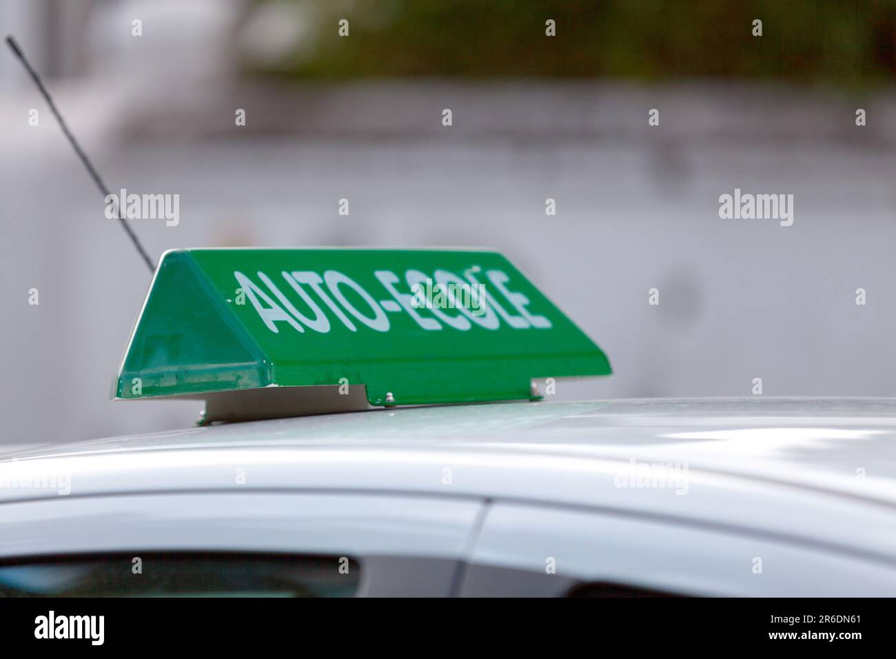 Green car roof sign saying in French 'Auto-Ecole', meaning in English 'Driving school'. Stock Photo
