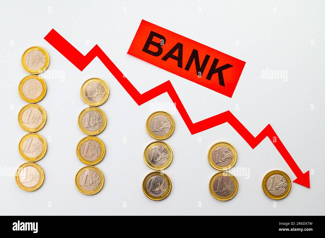 Rows of coins of descending height, descending red line, and the word