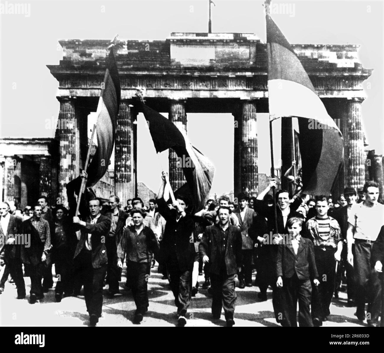 FILED - 17 June 1953, Berlin: East Berliners march through the Brandenburg Gate with flags waving from the East Sector. On June 17, 1953, a million people in the GDR protested against the still young socialist state - until Soviet tanks ended the uprising. Dramatic days. (to dpa 'When the tanks rolled: 70 years after the popular uprising in the GDR') Photo: dpa Stock Photo