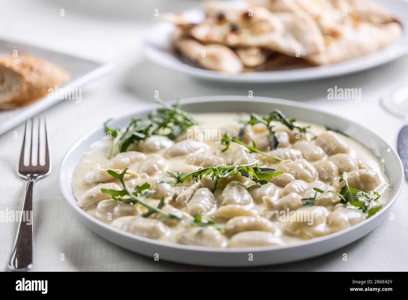Creamy gnocchi with four types of cheese and ruccola on top. Stock Photo