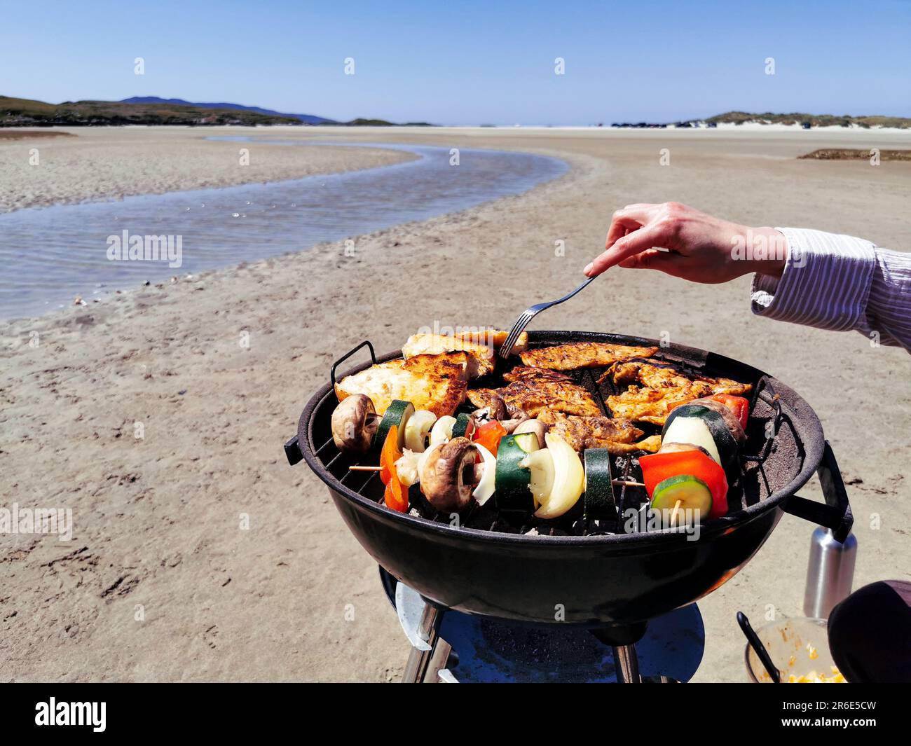 Making barbecue grill on sandy beach surrounded by mountains at Silver Strand, Thallabawn, Doovilra, Louisburgh, Co. Mayo, Ireland Stock Photo