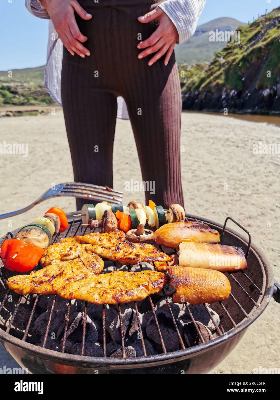 Making barbecue grill on sandy beach surrounded by mountains at Silver Strand, Thallabawn, Doovilra, Louisburgh, Co. Mayo, Ireland Stock Photo