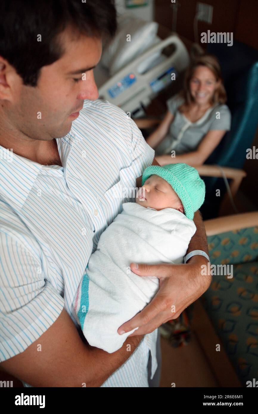 A father holds his new born daughter the day after she was born Stock ...