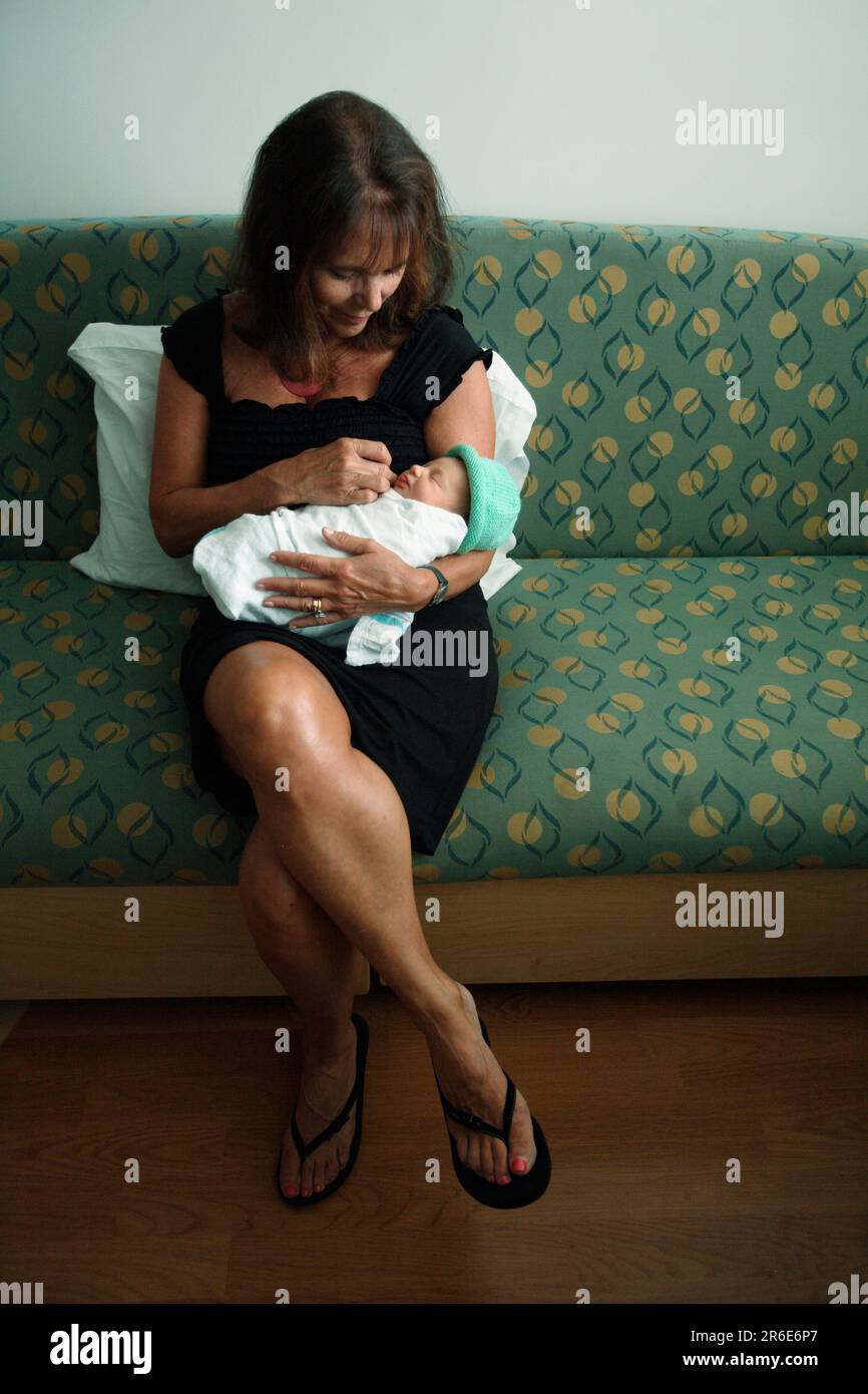 A woman holds a newborn baby girl the day after she was born. Stock Photo