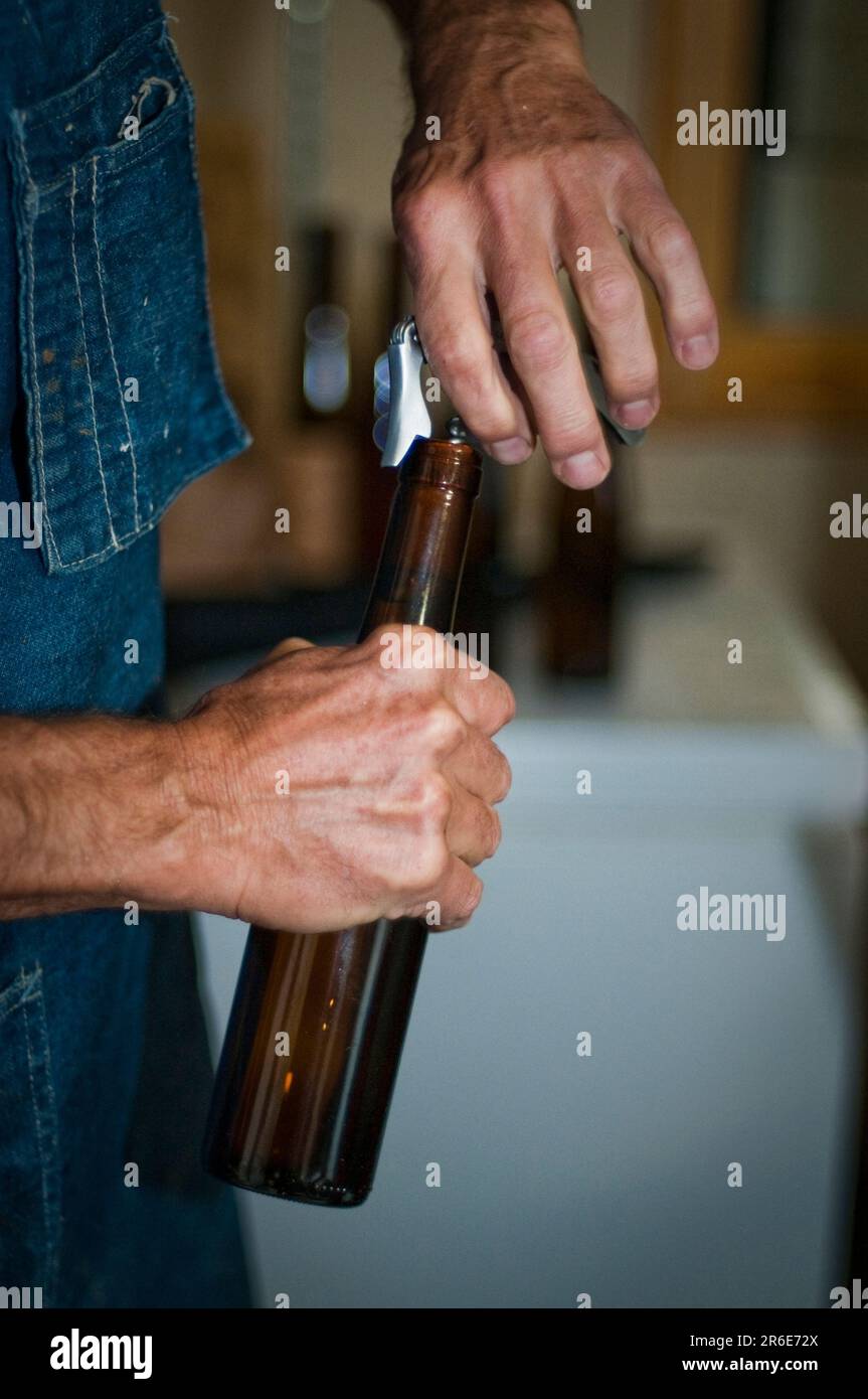 A MeadMaker, opens a bottle of Meadhoney wine Stock Photo Alamy