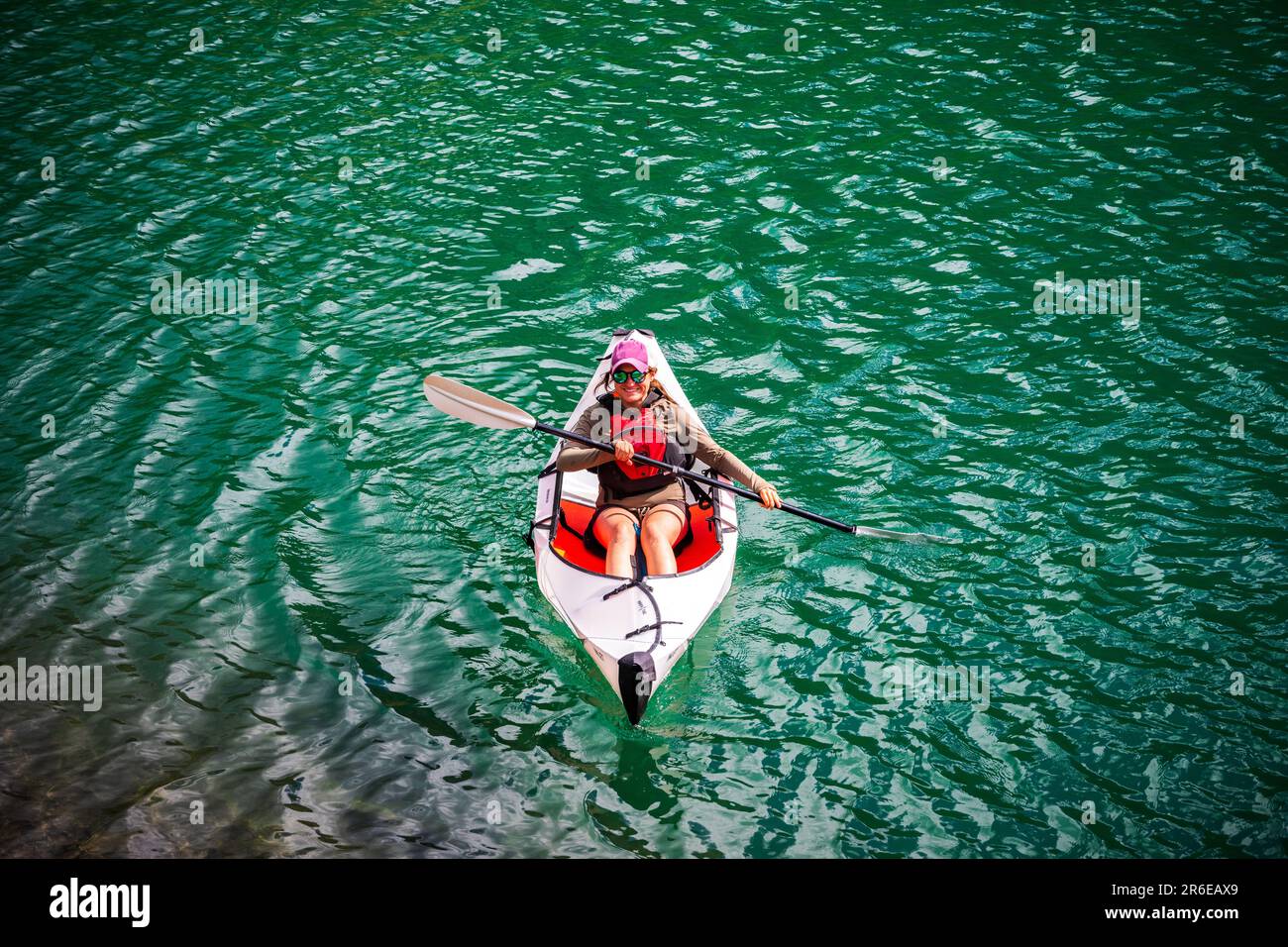 Woman Kayaking in Green Water Stock Photo