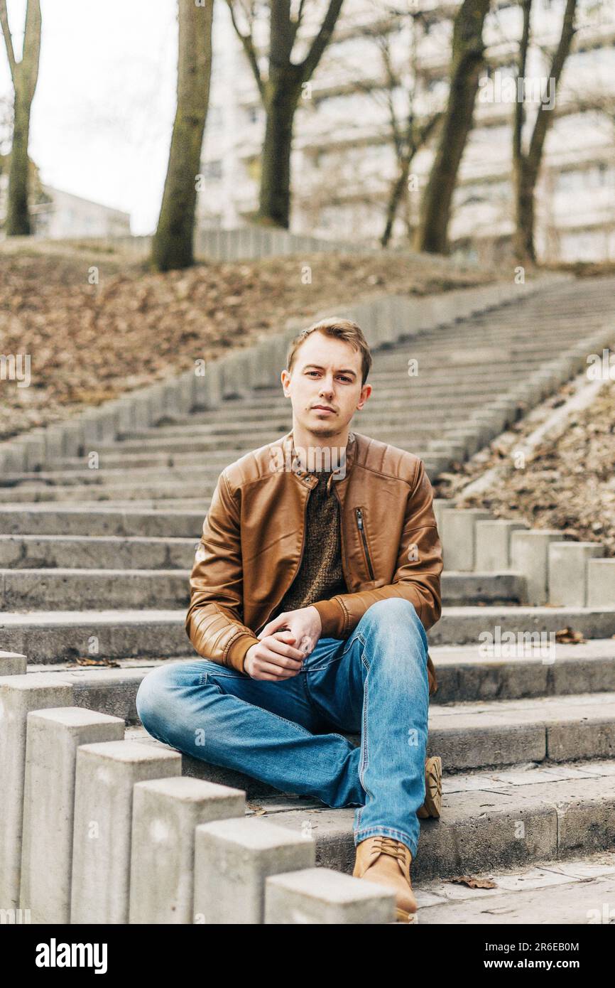 portrait of a young blond man in a brown leather jacket Stock Photo