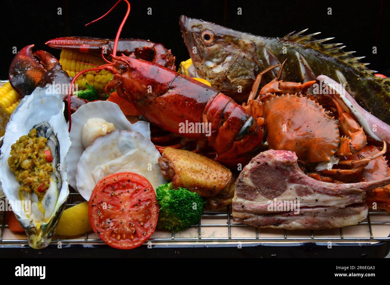 A platter of assorted seafood and meats is presented on a white plate Stock Photo
