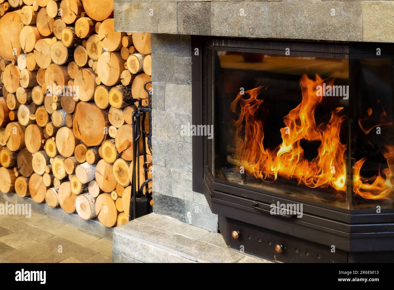 Stone Fireplace with Flames of burning fire, Rustic Style Cozy Home in Winter Stock Photo