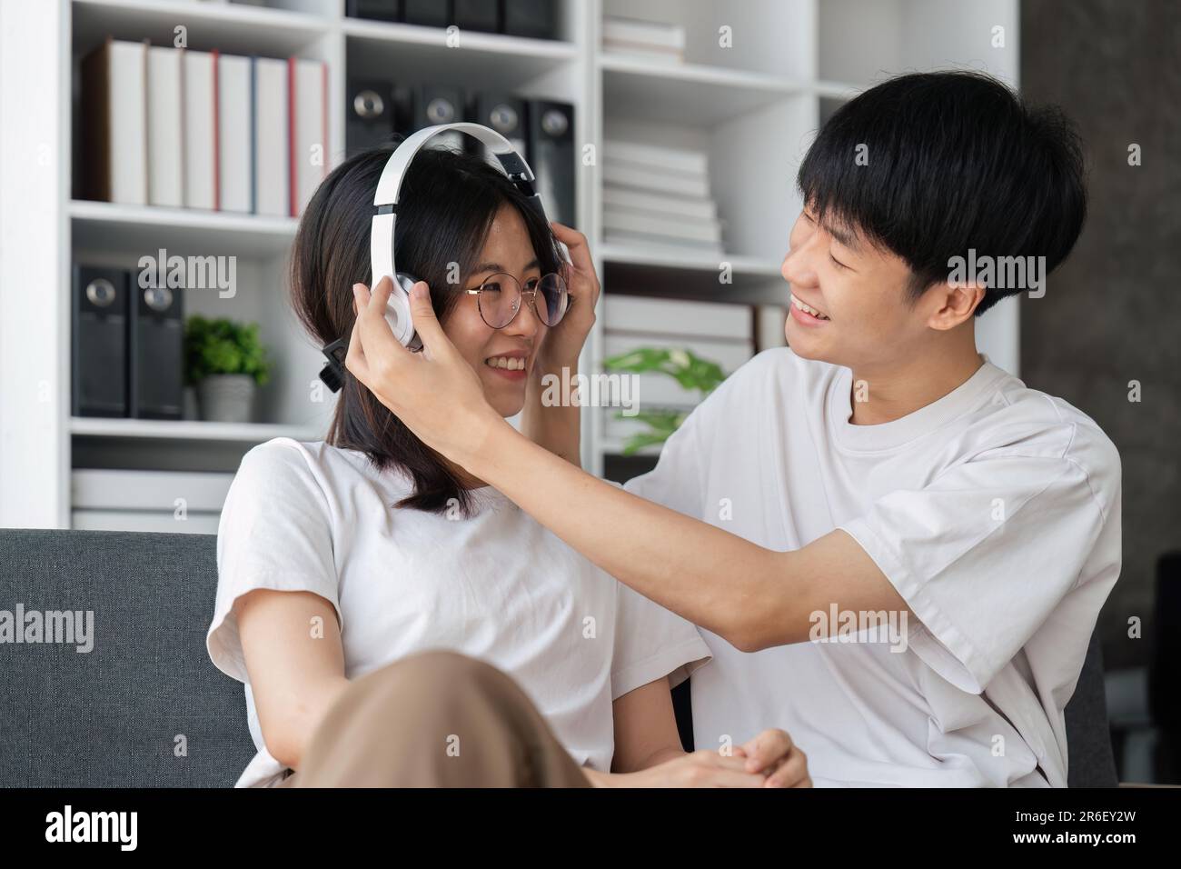 Activity at home concept, couple wears headphone to girlfriend and listening music together Stock Photo