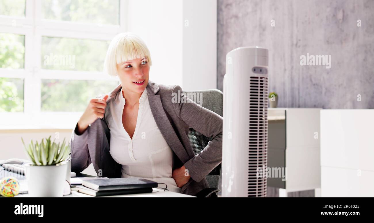 Electric Ventilator Fan In Hot Office Blowing Cool Breeze Stock Photo