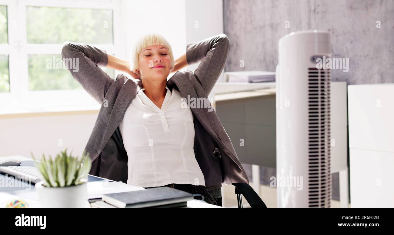 Electric Ventilator Fan In Hot Office Blowing Cool Breeze Stock Photo