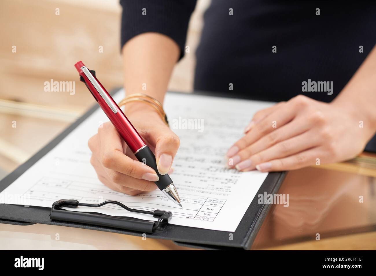 The hand of the woman who fills out medical records and questionnaires Stock Photo