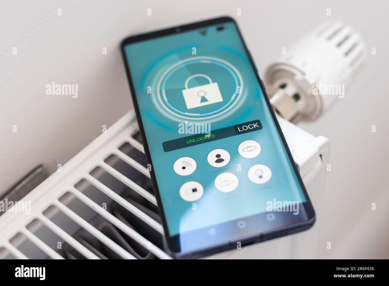 Smart Home: Man Controlling Heating Using App Stock Photo