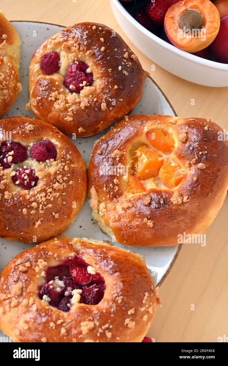 Homemade yeast rolls with fresh fruit: raspberries, strawberries, apricots Stock Photo