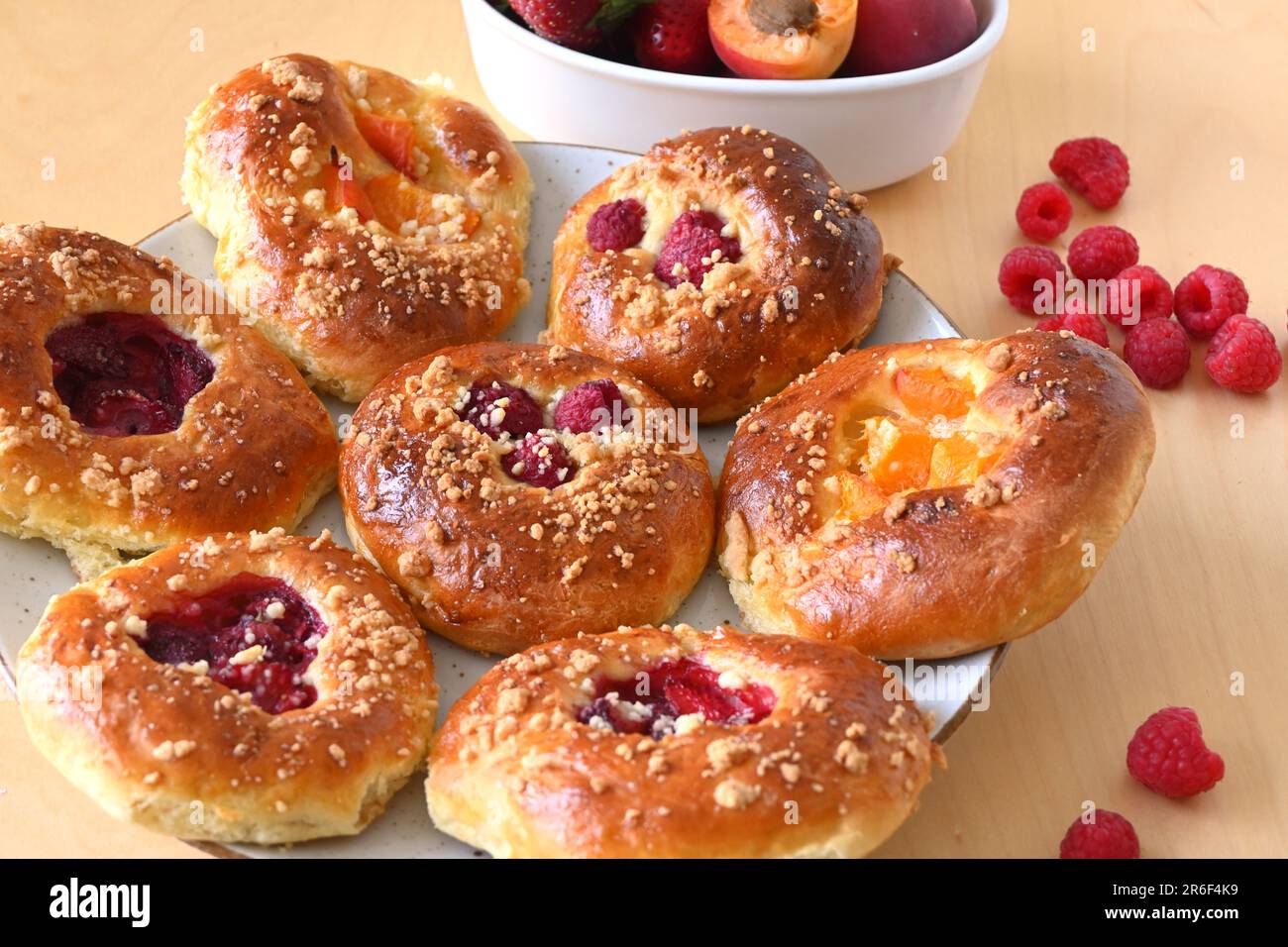 Homemade yeast rolls with fresh fruit: raspberries, strawberries, apricots Stock Photo