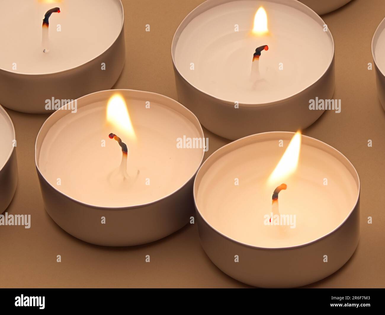 a group of white candles sitting in a bowl on a table. . Stock Photo