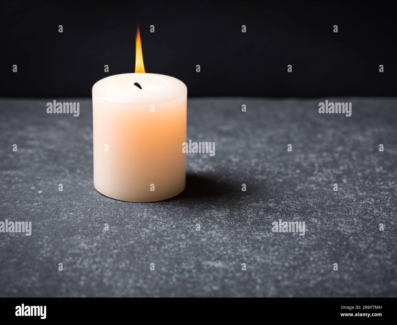 a lit candle sitting on top of a black table top. . Stock Photo