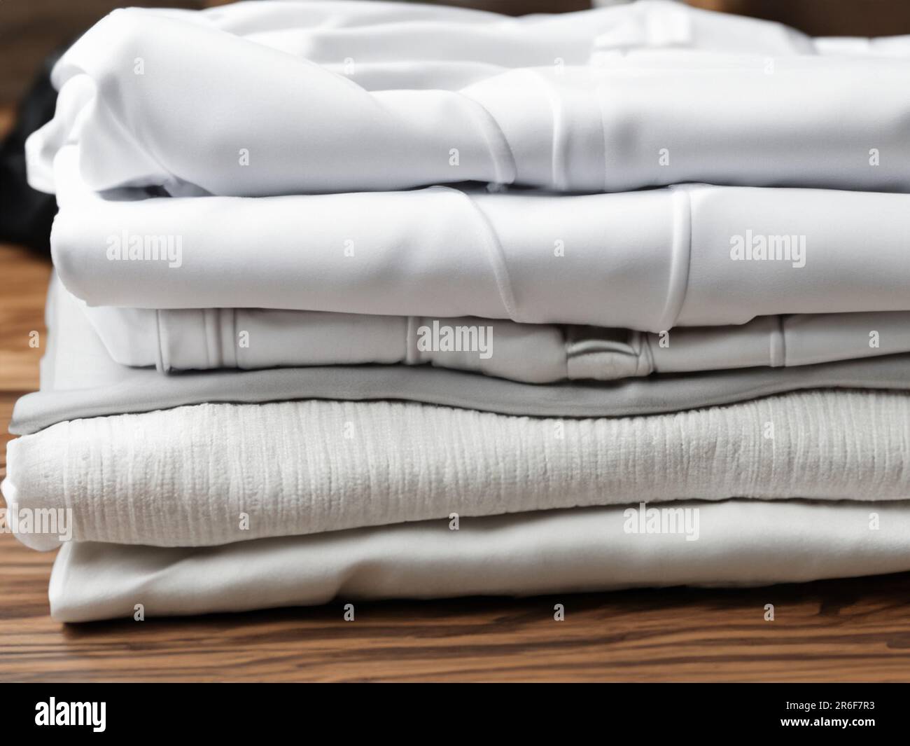 a stack of folded white sheets on a wooden table top. . Stock Photo