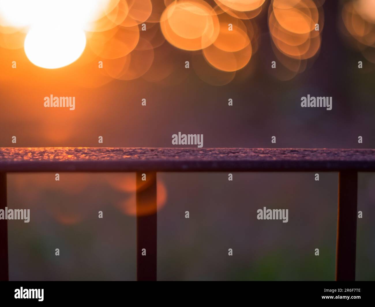 a blurry photo of the sun setting behind a fence. . Stock Photo
