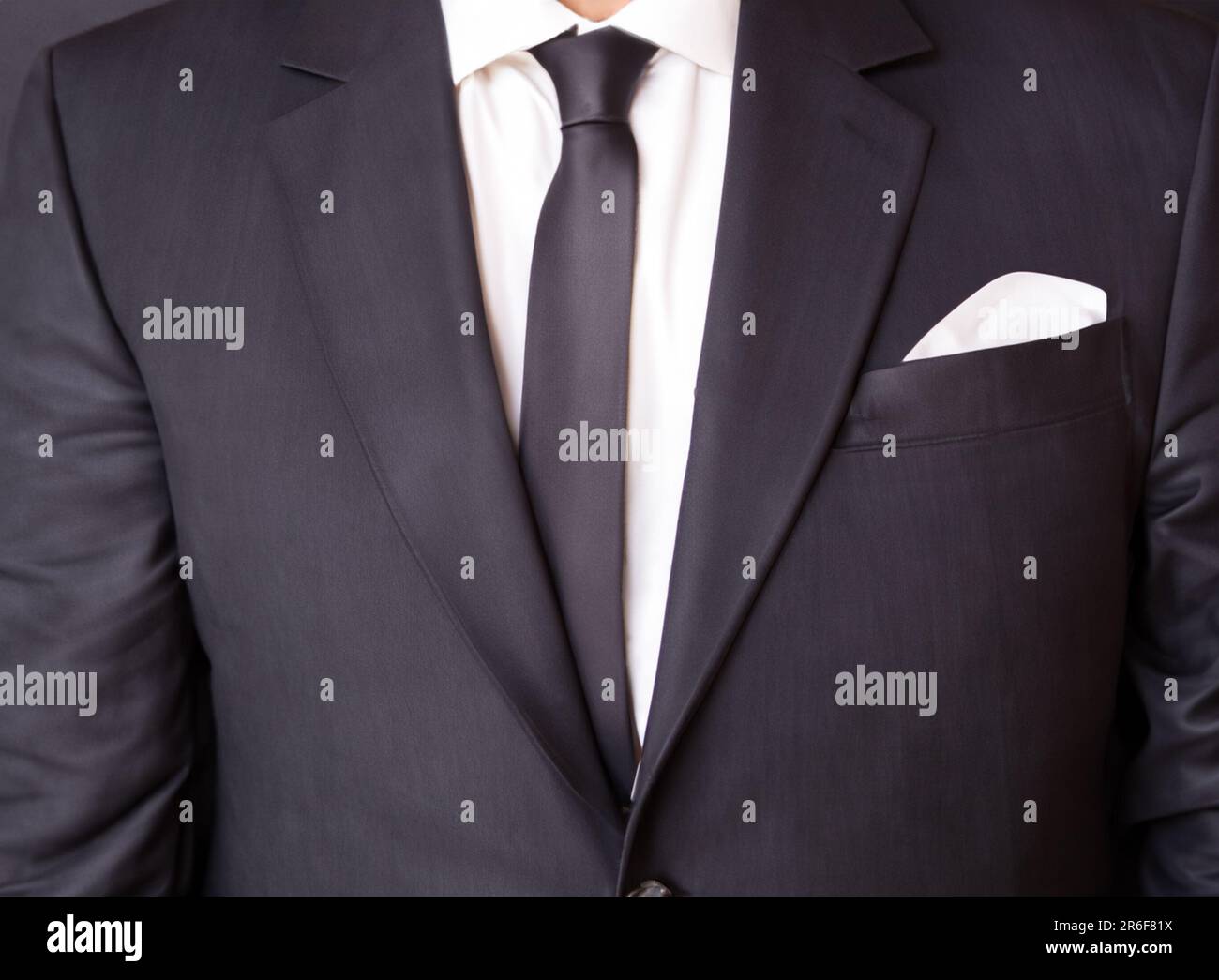 a man wearing a black suit and a white shirt and tie Stock Photo - Alamy