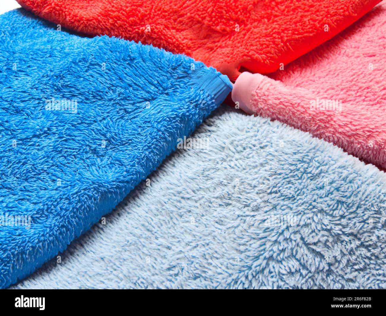 a close up of three different colored towels on a white surface. . Stock Photo