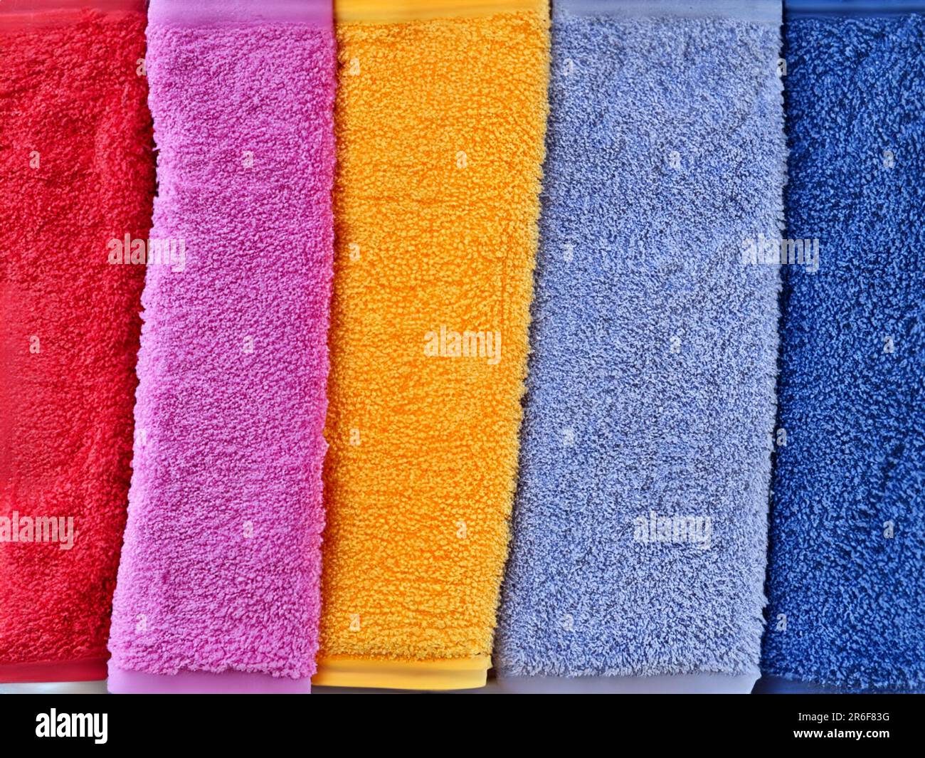 a row of colorful towels hanging on a rack in a row. . Stock Photo