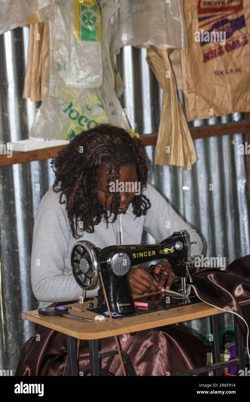 Seamstress with foot operated Singer sewing machine Photographed in