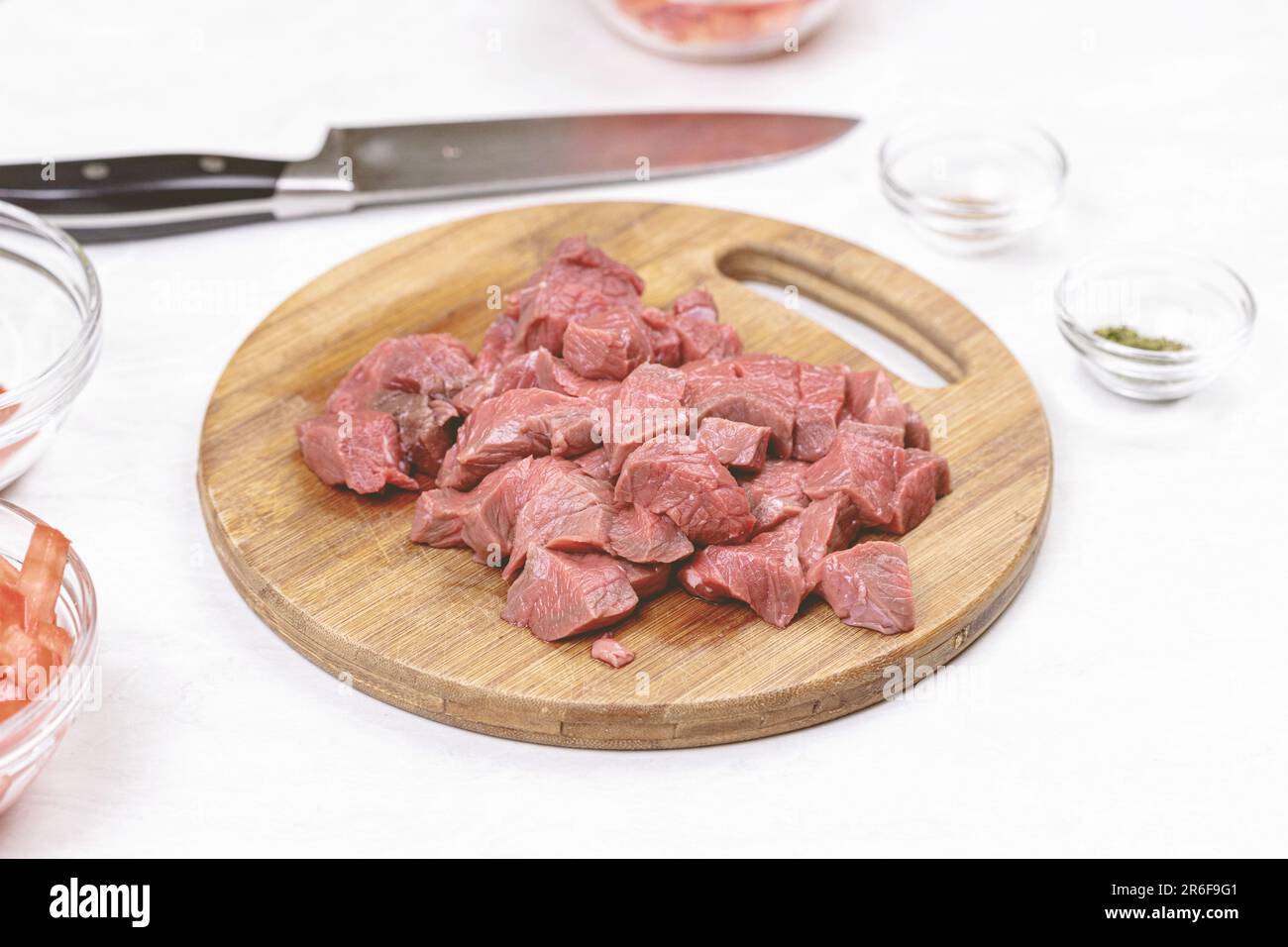 A cutting board with several pieces of raw, uncooked meat Stock Photo