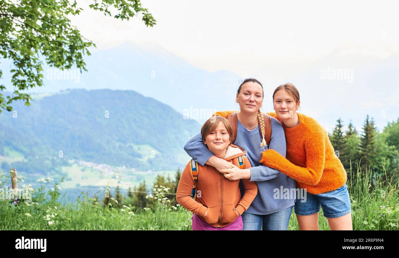 Mother with children hiking in mountains, active family time with kids Stock Photo