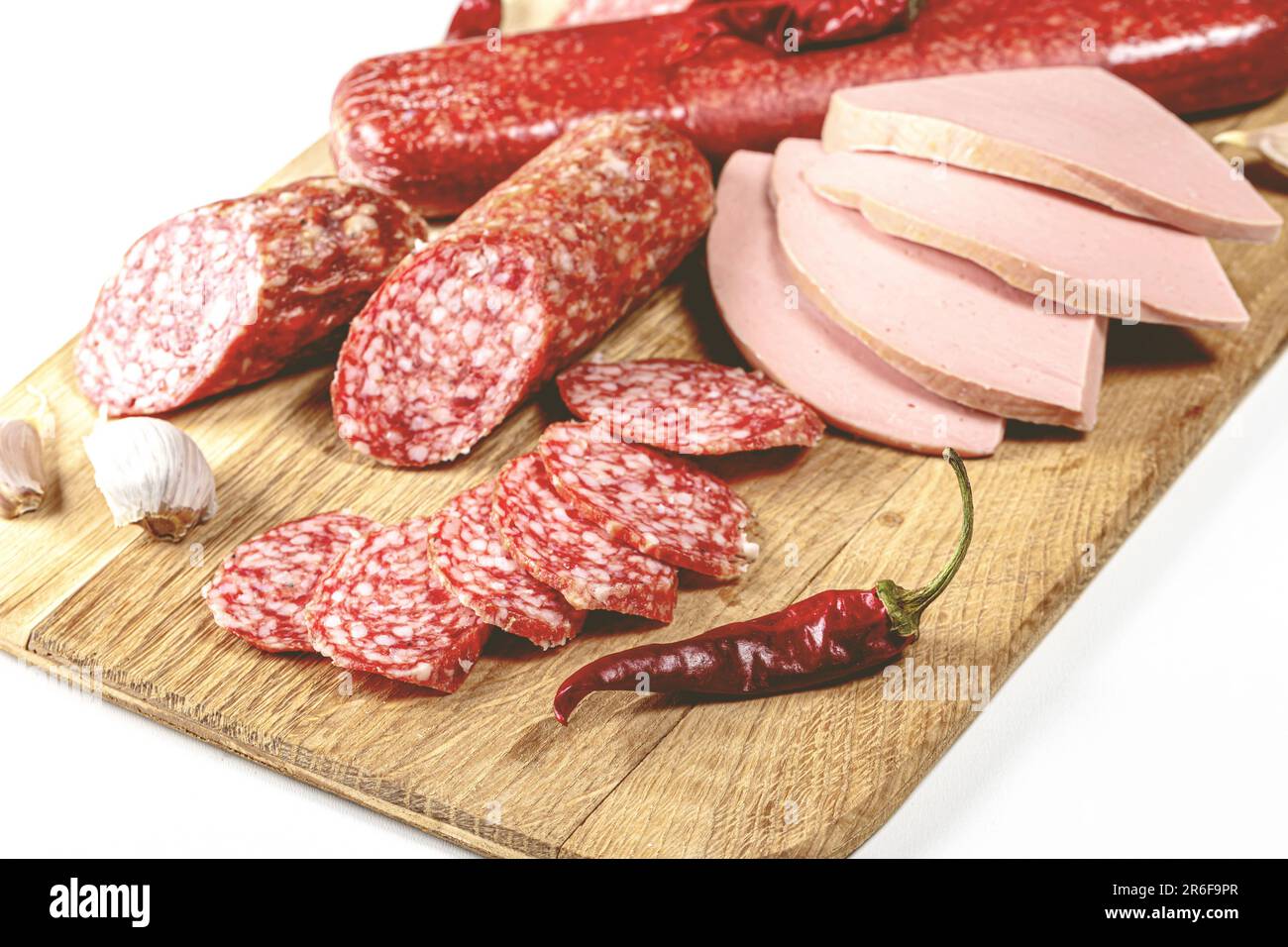 A close-up of a cutting board with an array of diced and sliced meats and vegetables, arranged in an aesthetically pleasing spread Stock Photo