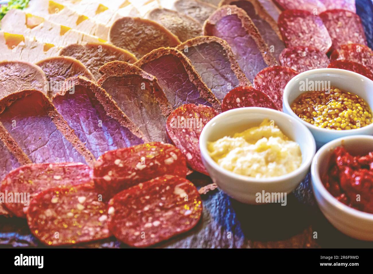 A large platter filled with a variety of charcuterie meats and dippers displayed on a table Stock Photo
