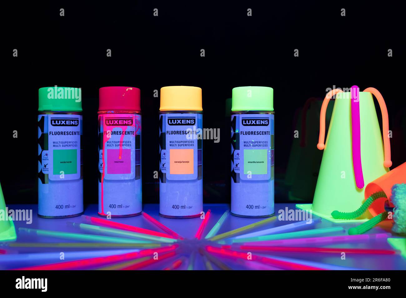 Detail of some cans of fluorescent spray paint with painted things that