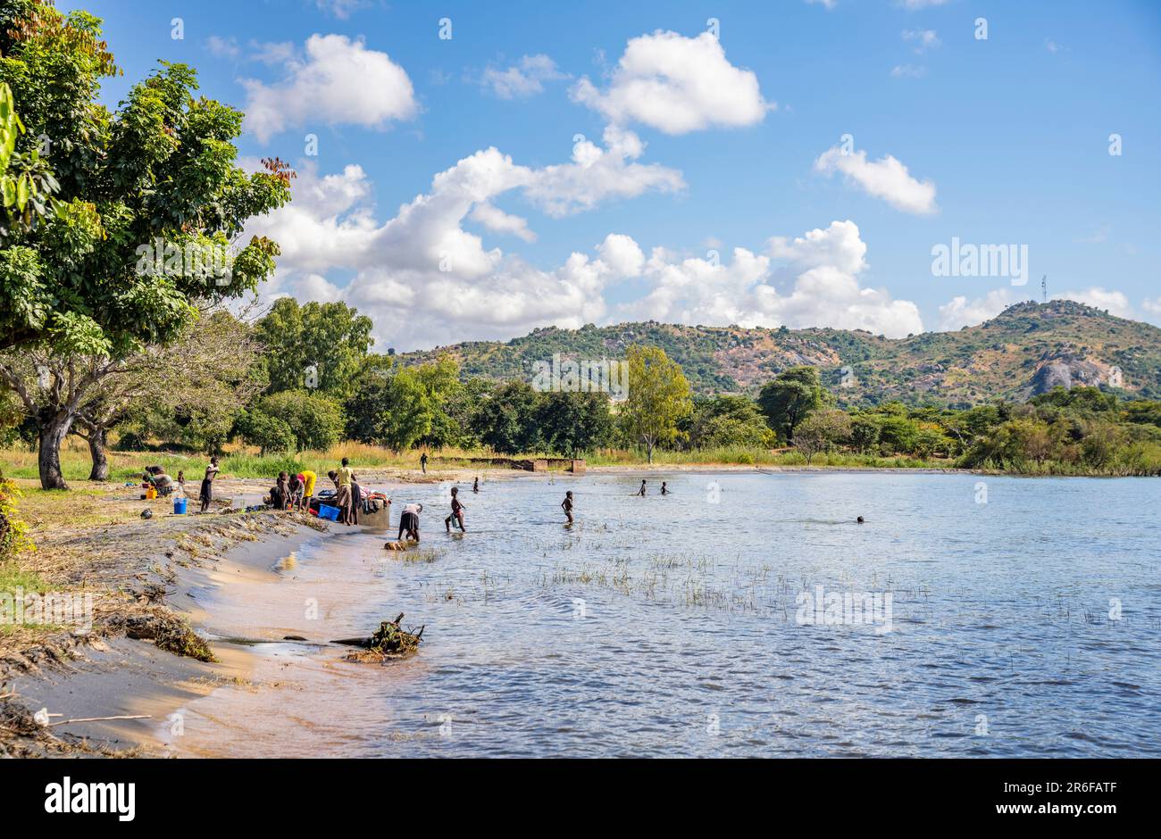 Villagers collect water and wash clothes on the shore of lake Malawi Stock Photo