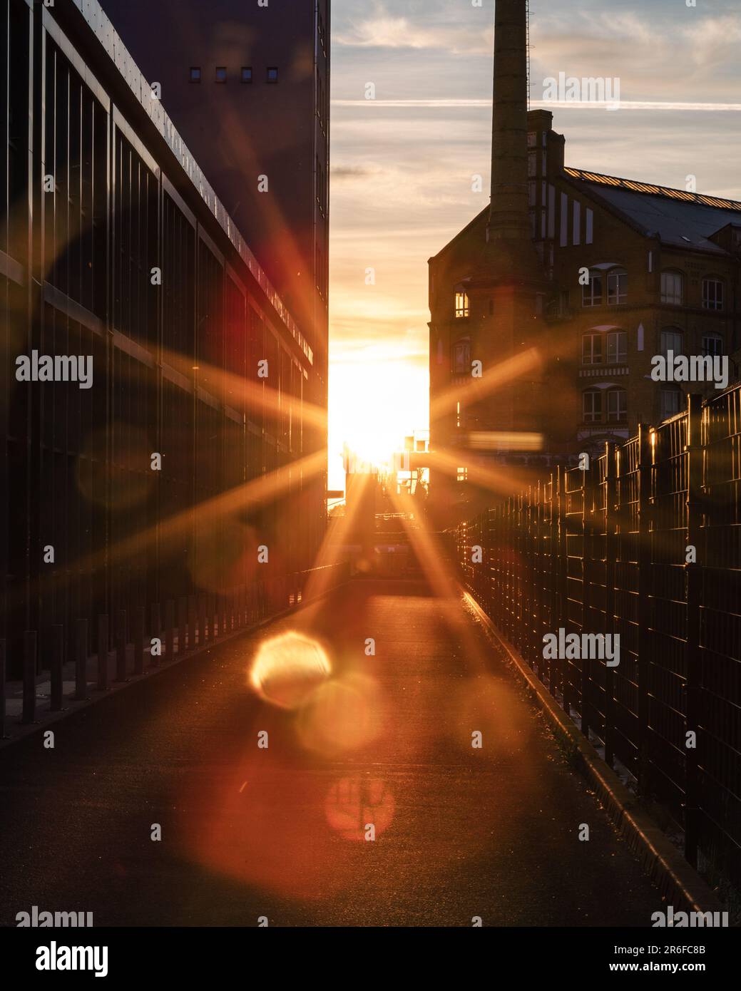 A sunset in an industrial area, showing lens flares. Berlin, Schöneweide. Stock Photo