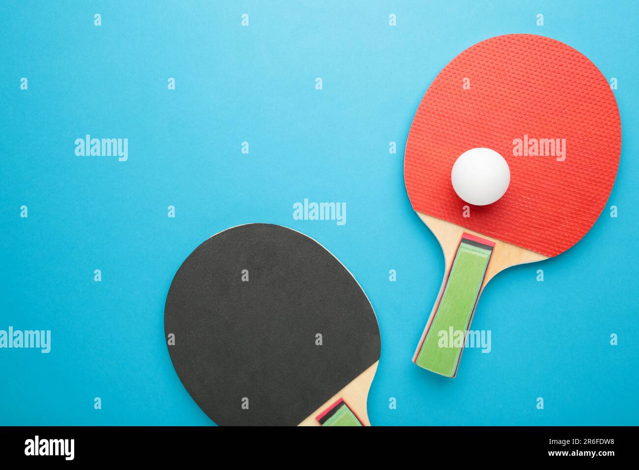 Ping pong rackets and ball on blue background. Top view Stock Photo