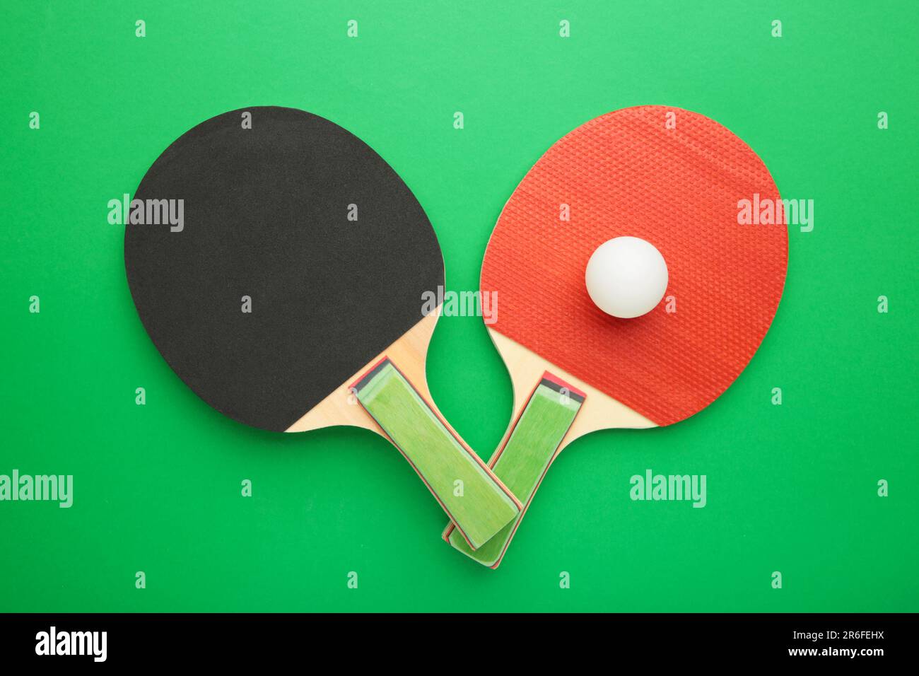 Ping pong rackets and balls on green background. Top view Stock Photo